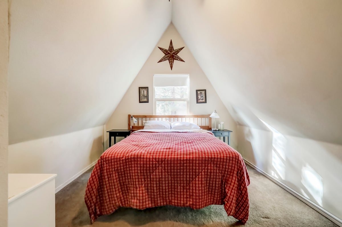 غرفة نوم في الطابق العلوي بسرير بحجم كبير وخزانات وباب