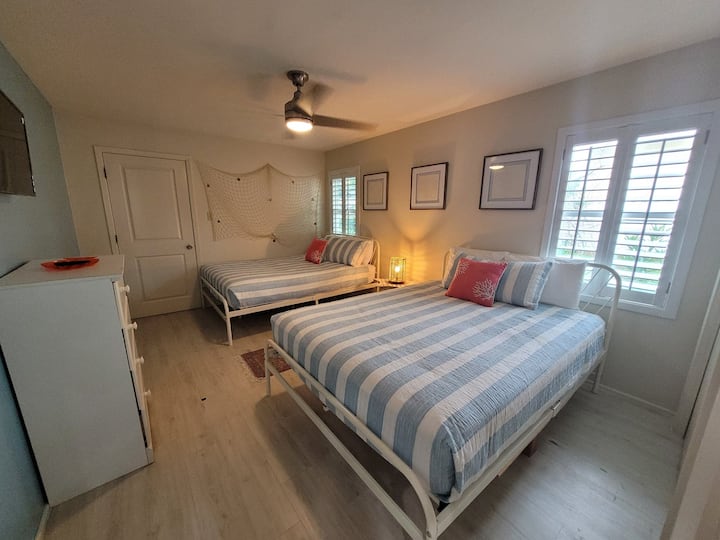 Chumba cha kulala cha wageni kilicho na vitanda viwili vya upana wa futi tano.