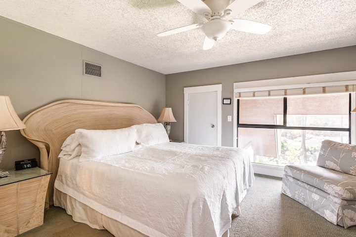 ห้องนอนชั้นบนมีเตียงคิงไซส์โต๊ะข้างเตียง 3 ตัวช่องระบายอากาศพัดลมเพดานทีวีเก้าอี้เลานจ์ขนาดเล็ก 2 ตัว