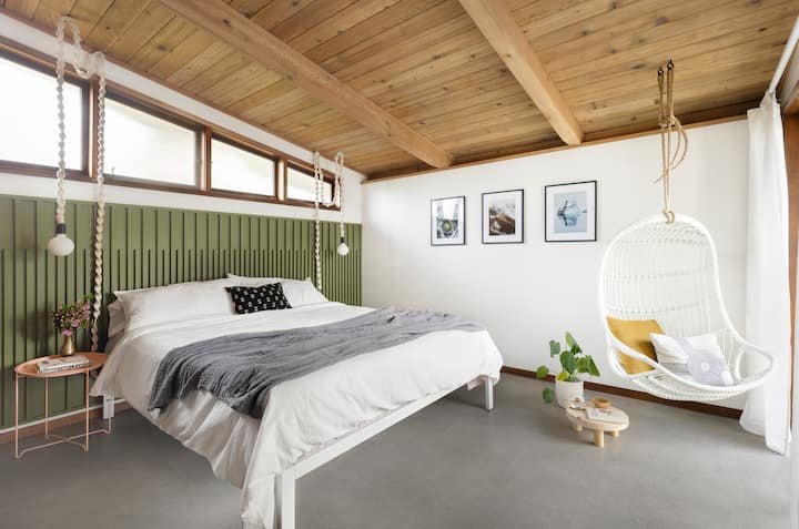 Dormitorio principal con una cama California King, un gran armario y una puerta corrediza al patio trasero. 