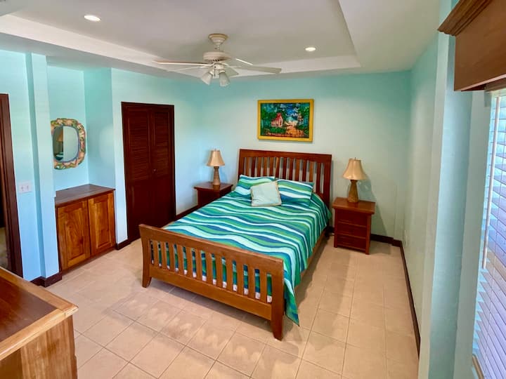 Spálňa s manželskou posteľou Queen a vlastným umývadlom.