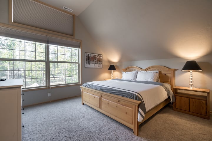 Large upstairs master bedroom with scenic view of the trees at the back of the house