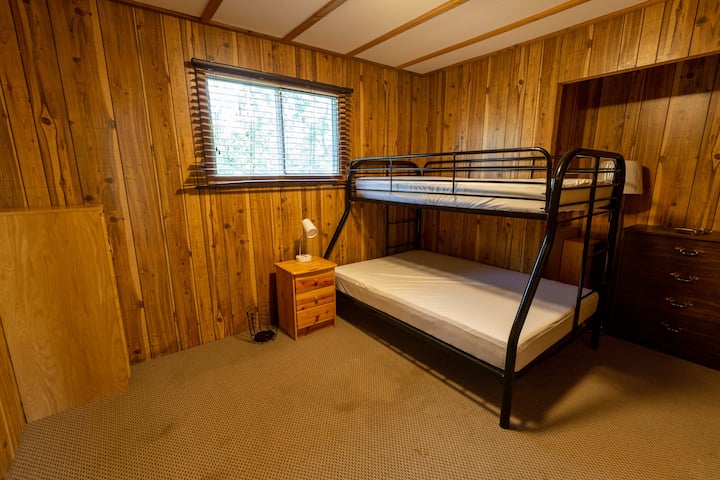 Dormitorio para niños con litera doble de tamaño inferior y cama individual superior.