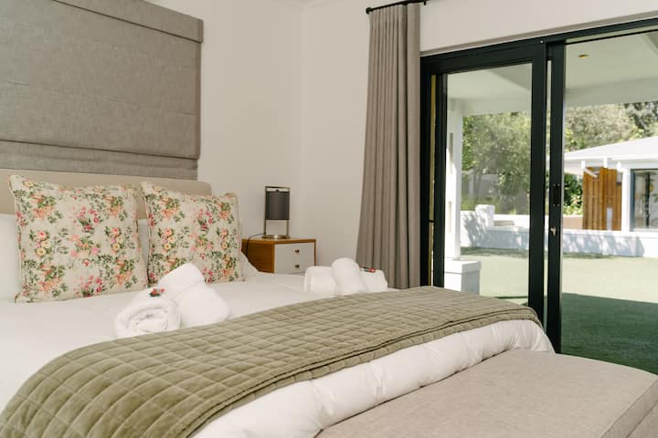 Kamar tidur utama dengan kamar mandi di dalam. Pemandangan ke area taman.