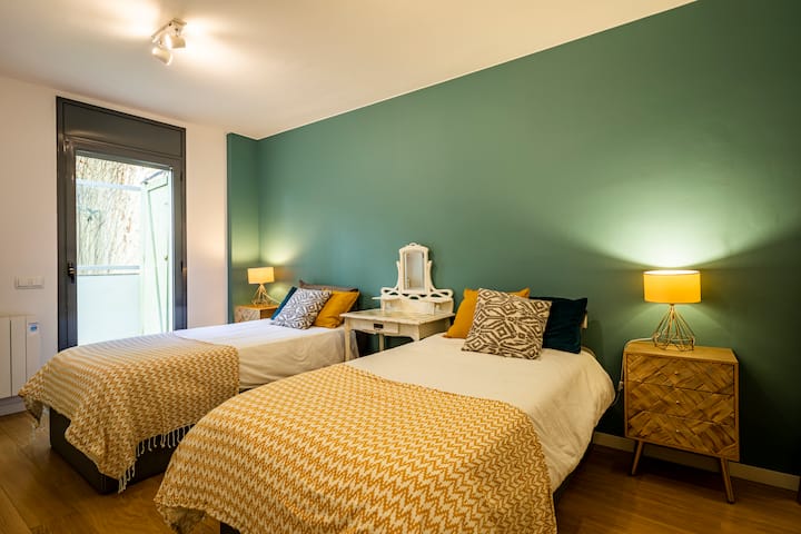 Chambre avec lits jumeaux verts sur le balcon.
