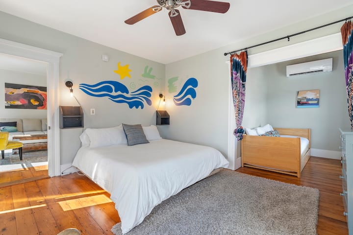 El dormitorio está bien iluminado, con amplia luz natural que entra por las ventanas, creando un ambiente cálido y acogedor. Este dormitorio principal es el refugio perfecto para que los huéspedes disfruten de una noche de sueño reparador rodeado de comodidad y belleza.