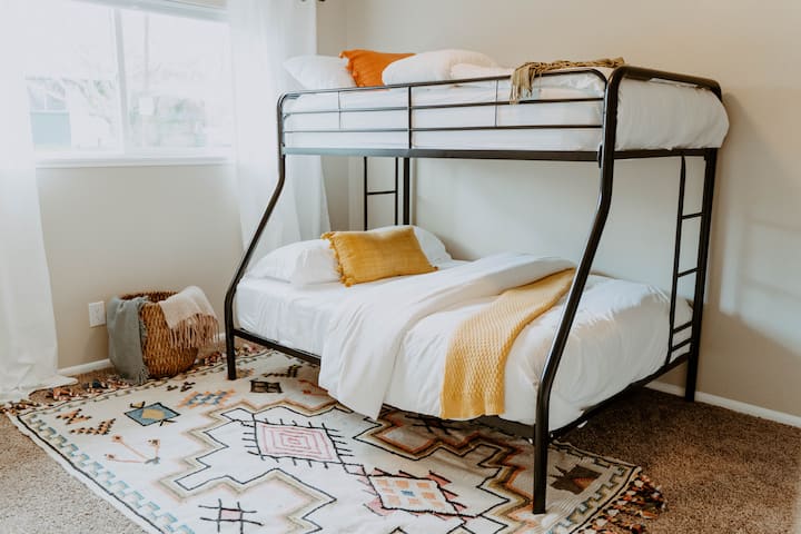 Quarto três equipado com um colchão completo e duplo, edredons e lençóis brancos nítidos.