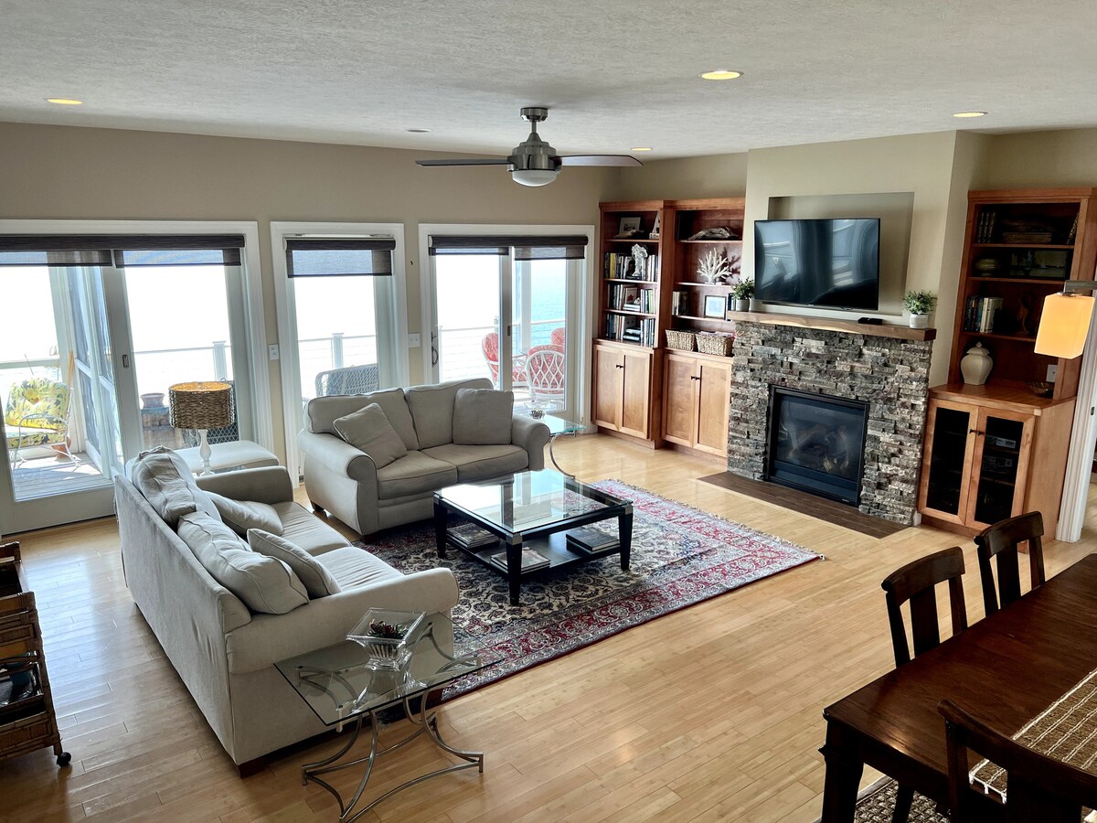 غرفة معيشة وغرفة طعام مفتوحة، تحتوي على أريكة نوم بحجم كوين