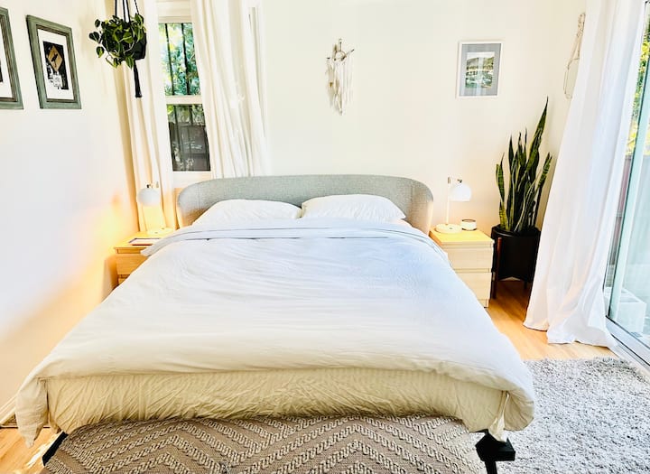 Queensize-Schlafzimmer öffnet sich zu einer großen Terrasse mit Sonnenschirm und Terrassenmöbeln - ideal für Mahlzeiten im Freien.