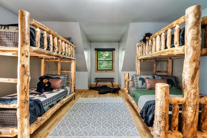 Alpine Cedar log bunk beds. The bunk room can sleep 5 and bring a sleeping bag and someone can sleep in the indoor playhouse.