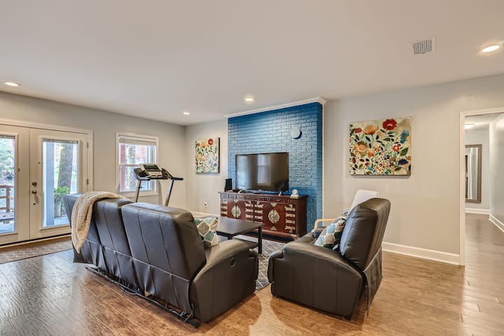 Salle familiale avec une table à manger, une télévision connectée 4K grand écran et des canapés au niveau inférieur
