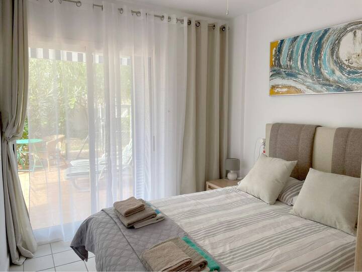A bedroom with a double bed and direct access to the terrace. The bedroom has a large 3-door wardrobe with a mirror.