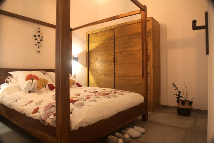 La chambre parentale : un lit à baldaquin queen size (160*200, des voiles ont été ajoutés) et une armoire en bois massif réalisée sur mesure pour vos affaires. 