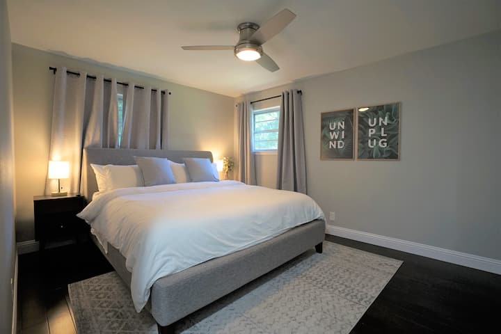 غرفة نوم رئيسية هادئة بسرير كبير وحمام كامل برأس دش في الغابة المطيرة وتلفزيون.