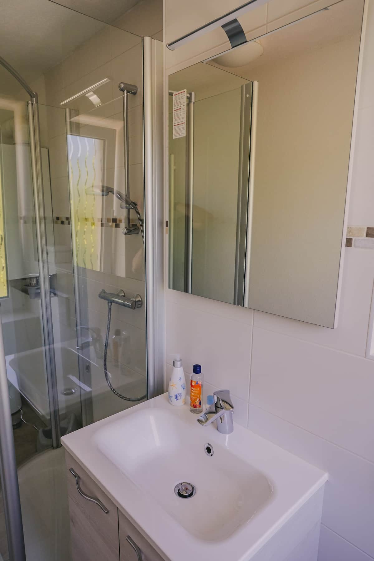 Badezimmer mit Dusche und Waschbecken