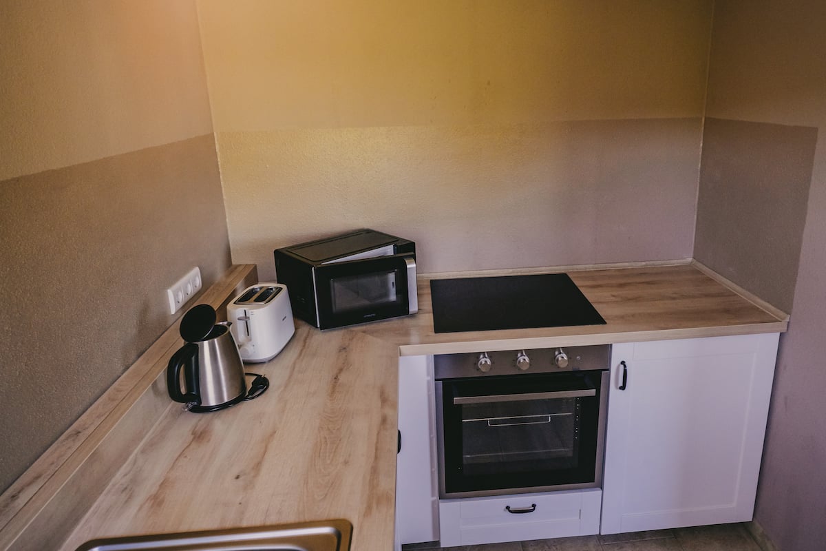 Küche mit Herd, Backofen und Mikrowelle