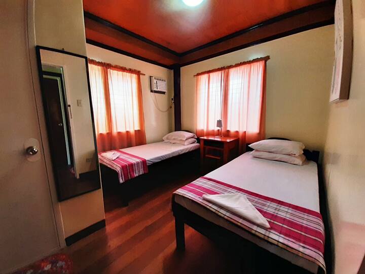 Room 2.  Two  single beds with working table and dedicated toilet/bath.
