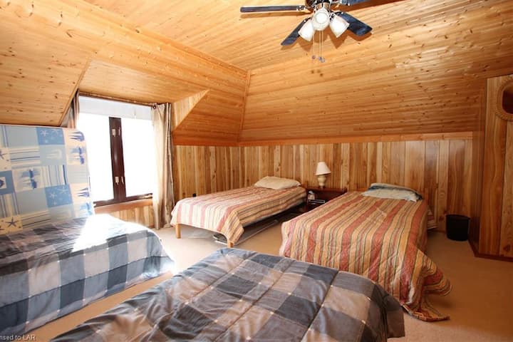 Détendez-vous dans cette chambre à l'étage avec 4 lits simples confortables et un ventilateur de plafond pour une nuit reposante, un délice absolu pour les enfants !