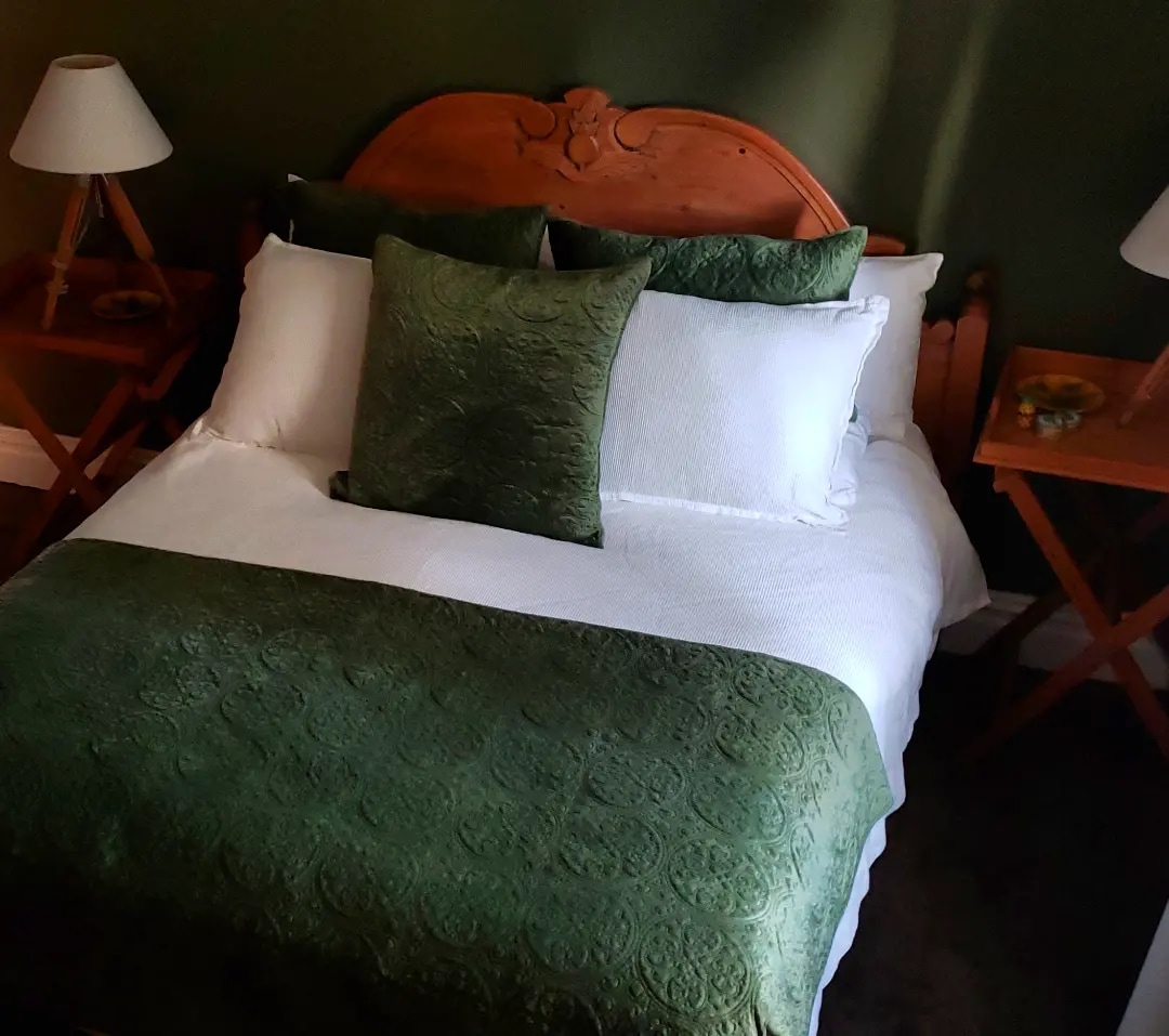 Habitación Hermitage, lujo de descanso en verde para atraer a la montaña a la habitación. Cama tamaño king ortopédico, ropa de cama de lujo, muebles antiguos de pino irlandés, hermosa vista del monte Pirongia desde la cama. 