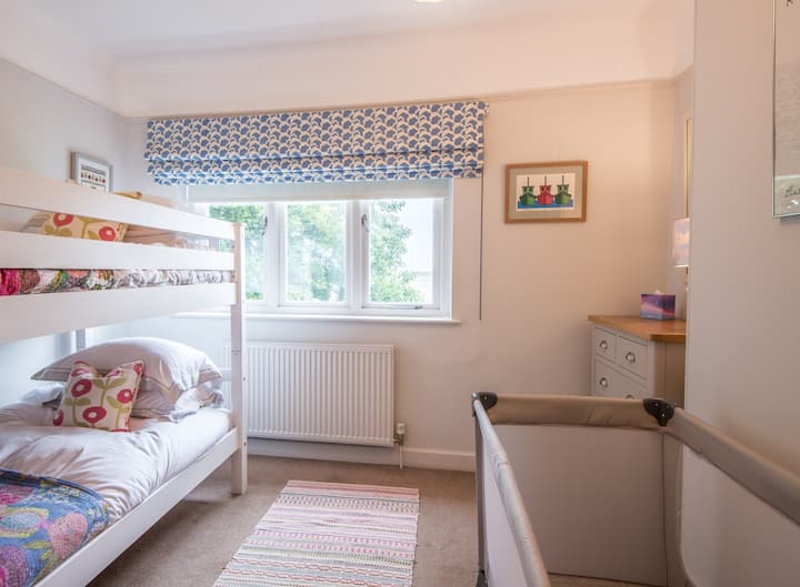 Spavaća soba s 5 kreveta na kat i putni krevetić. Pogled na vrt i močvaru.