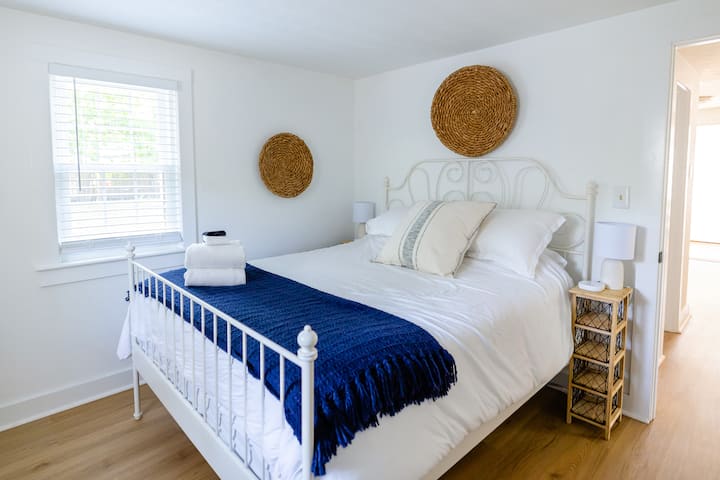 In the primary bedroom, you'll find a comfortable queen bed, dresser, and TV.