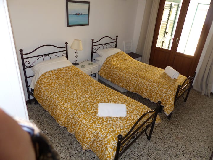 غرفة نوم تضم سريرين صغيرين