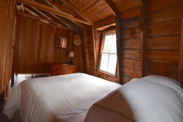 غرفة النوم الخلفية. يتم فصل الغرف بجدران بسيطة لا تصل إلى الأرضية. وهو كما تم بناؤه من قبل مزارع محلي قبل أكثر من 100 عام.