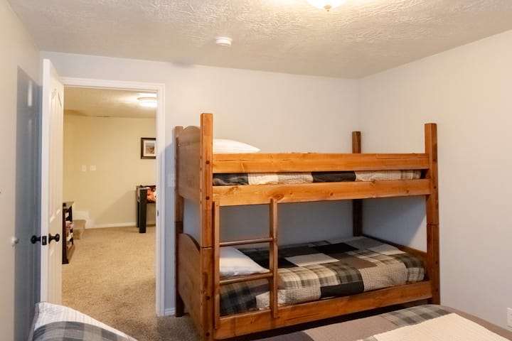 Bedroom 4 in basement with queen bed and bunk beds.