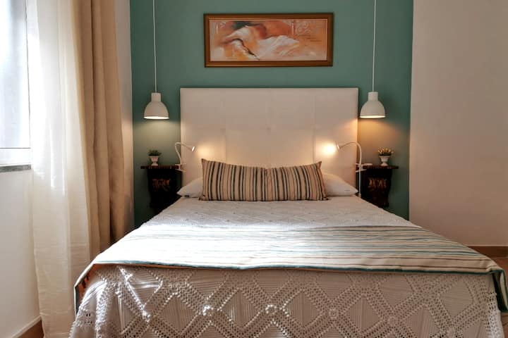 Спалнята разполага с двойно легло, гардероб и вентилатор на тавана.