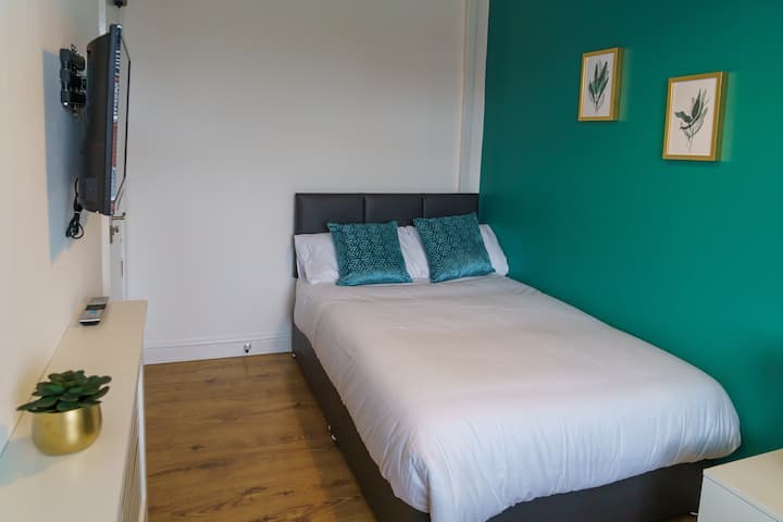 Colourful bedroom with comfortable double bed that has fresh linen and towels. 