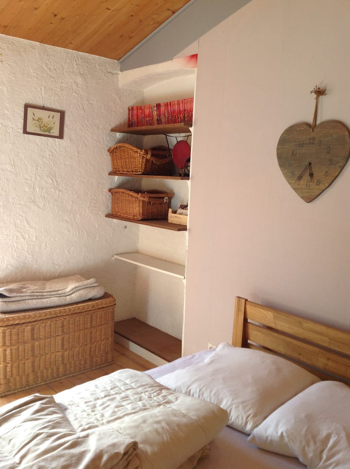 يوجد في غرفة النوم سرير مزدوج ومكتب ومساحة كافية لوضع سرير مظلة فيه. 