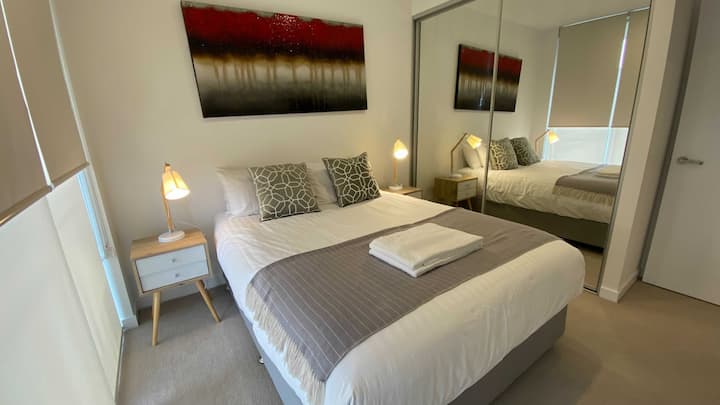 温馨舒适的卧室，侧面有标准双人床和灯罩。 还有一个橱柜，可滑动滑动镜面门，您可以在那里放置衣服和其他物品。 放松身心和睡觉的完美场所。