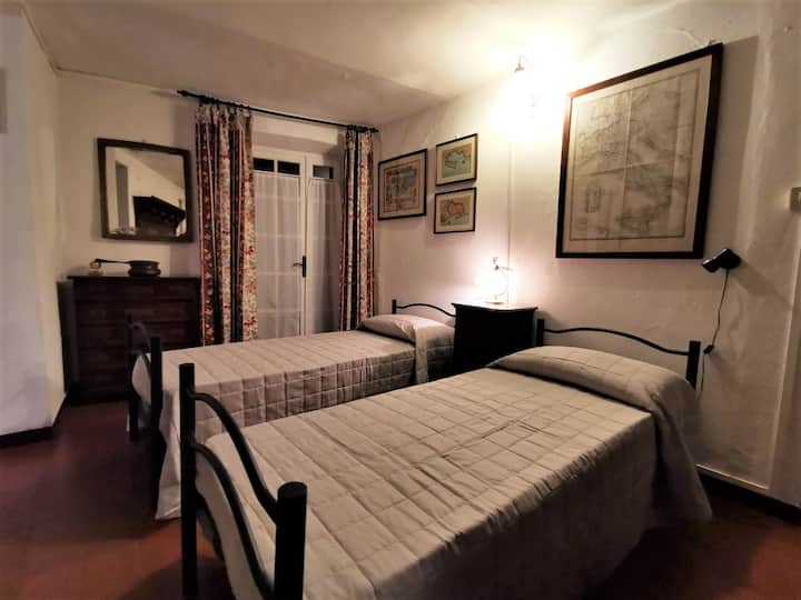 Spálňa s dvoma samostatnými lôžkami, starožitným šatníkom a šatníkom.