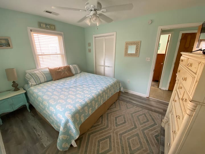 Primary bedroom has a King size bed for guests to enjoy. Linens & pillow cases are not provided. The ceiling fan is wonderful on hot, summer nights.