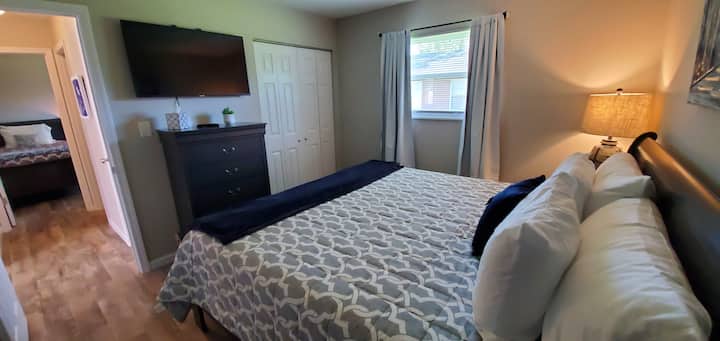 这间卧室配有特大双人床、衣柜、梳妆台和电视。