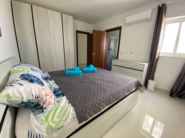 Dormitorio doble principal con una cama grande y baño privado