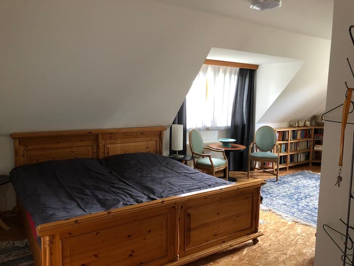 Large bedroom with double bed and sitting area under the south window
