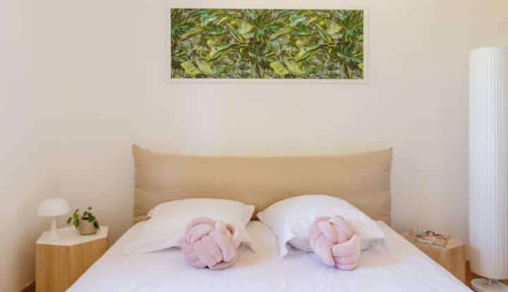 спална соба на приземје со брачен кревет, приклучоци со полначи за телефон или компјутер.