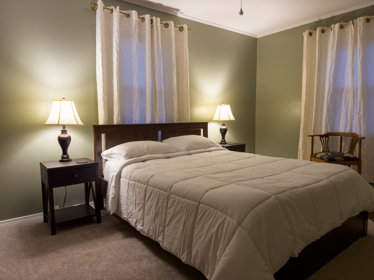 Queensize slaapkamer met laden en grote kastruimte.