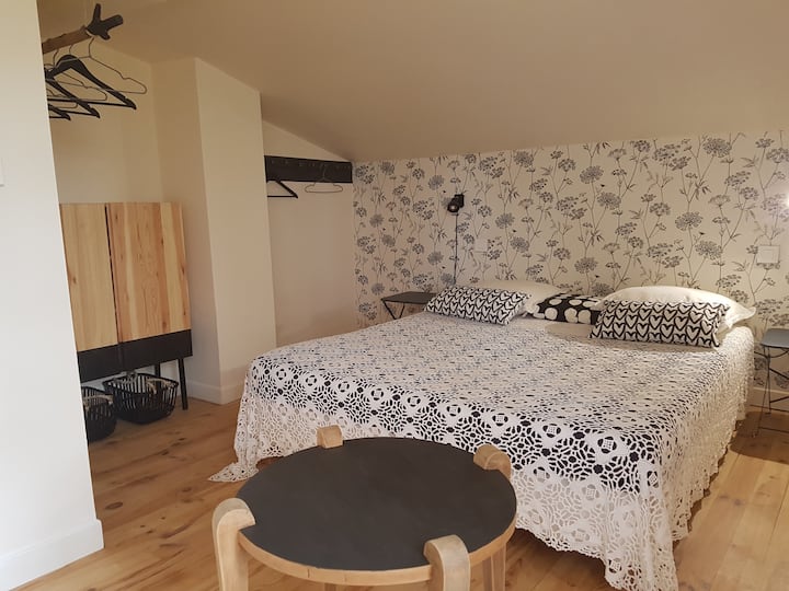 Spavaća soba u crno-bijeloj boji, krevet od 160 cm može se podijeliti na 2 kreveta od 80 cm. Kroz prozor se pruža pogled na krajolik s prednje strane kuće.