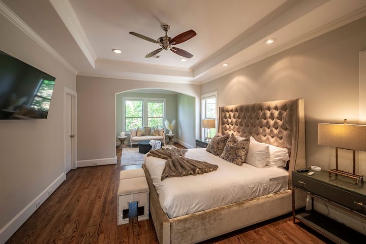 Огромна родителска спалня със самостоятелен кът за сядане. 