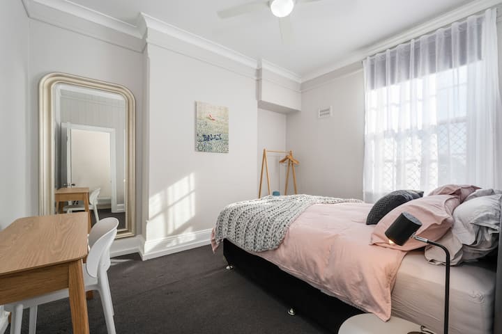 Level 1 bedroom with queen bed, hanging space and desk. 