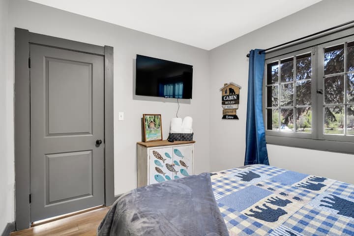 Room 1 connects from the living room. It has a view overlooking the lake. It also has a smart TV—the nightstand has a USB port and an outlet.
