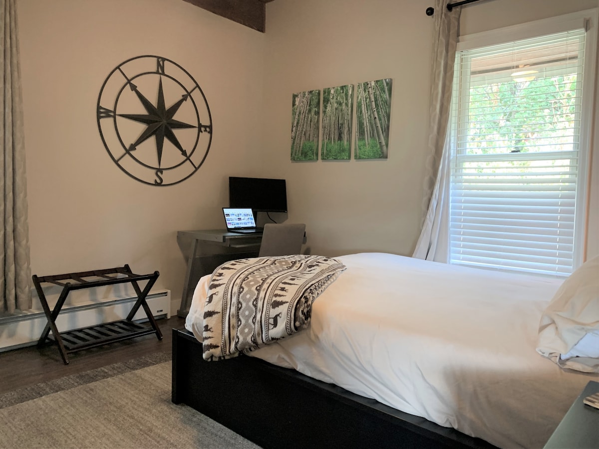 غرفة نوم بسرير كبير مع ضوء رائع ومحطة عمل