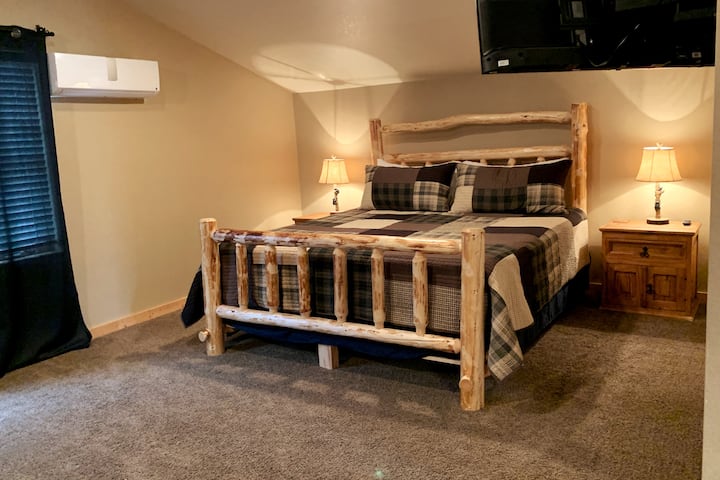 Huge rustic log king size bed with AC unit and TV. Cozy up with your sweetie (and/or the kids) in this comfy bed for TV-watching away from the common space!