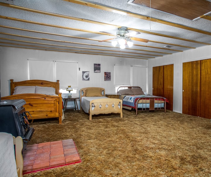 Chumba cha kulala cha pili chenye nafasi kubwa kinalala hadi sita na vitanda kimoja vya kifalme, single mbili na kitanda kimoja cha ukubwa kamili