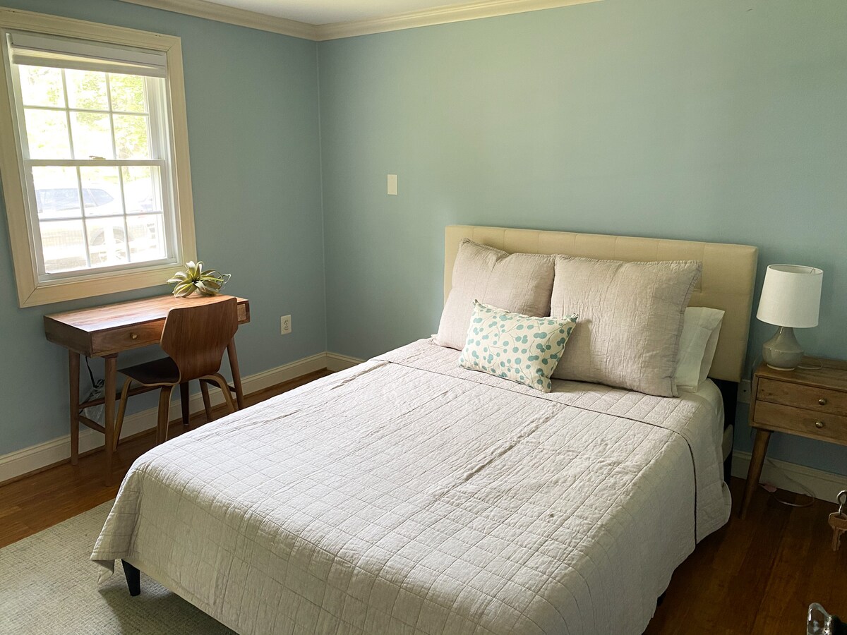 تحتوي غرفة النوم في الطابق الرئيسي على سرير بحجم كبير ومكتب للعمل. 