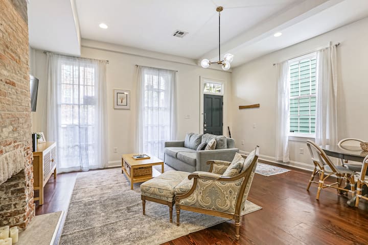 Comfortable living space with large windows and lots of natural light. Smart TV and cabinet filled with games and books (for adults and kids). Note the high ceilings and oversized windows (typical for homes of this area), which add to the airy feel.