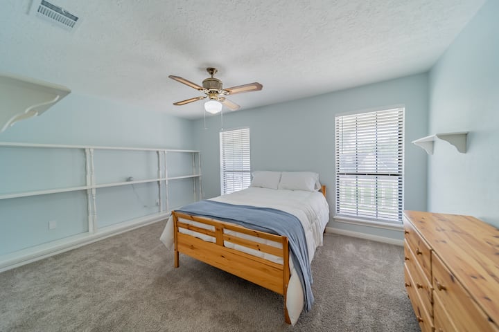 Plava spavaća soba s krevetom pune veličine, Smart TV-om i pametnim zvučnikom. 