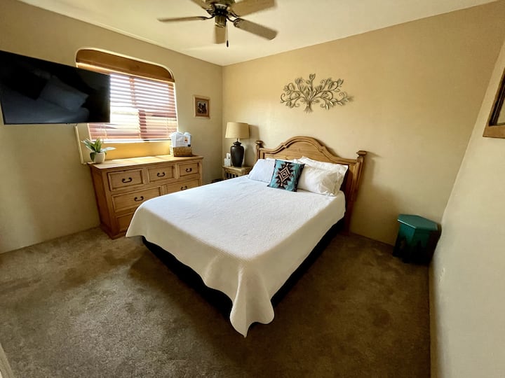 Pohodlná spálňa pre hostí s manželskou posteľou Queen, s výhľadom na tichú záhradu a umývanie, inteligentnou televíziou a stropným ventilátorom